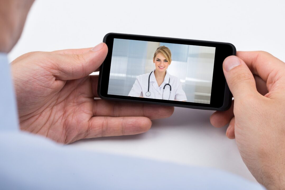 Person Videochatting With Doctor On Mobile Phone